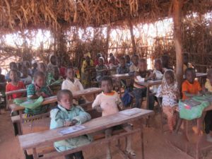 Children learning in a temporary classroom.